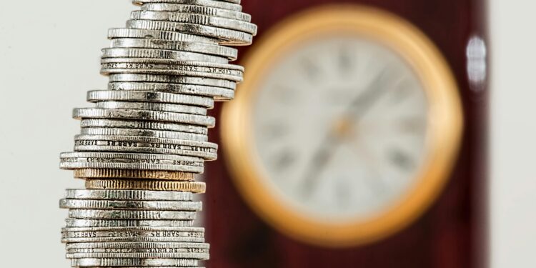Stapel munten met klok op achtergrond als symbool voor financiële vrijheid en de waarde van tijd