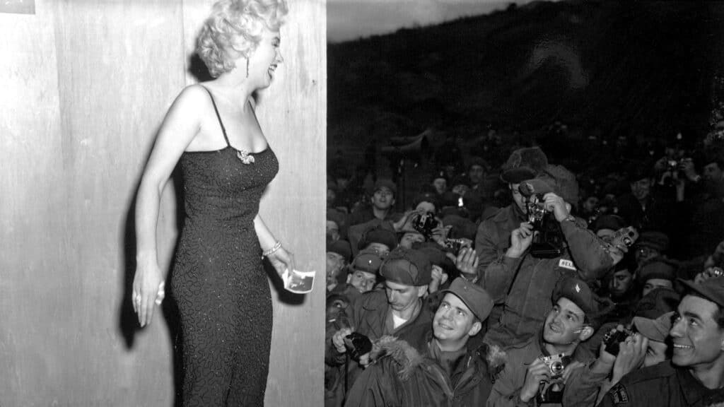 Van Marilyn tot TikTok: hoe ons schoonheidsbeeld is verschoven 2 Marilyn Monroe in nauwsluitende jurk op podium, lachend naar juichende menigte van soldaten, beeld voor veranderende schoonheidsidealen